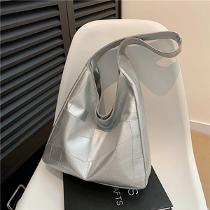 Silver metallic tote bag with geometric stitching on a modern chair