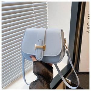 Detail of light blue crossbody bag with gold H-buckle and elegant smooth leather texture