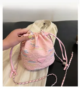 Dettaglio della borsa a secchiello rosa con trama intrecciata e ricamo a onde
