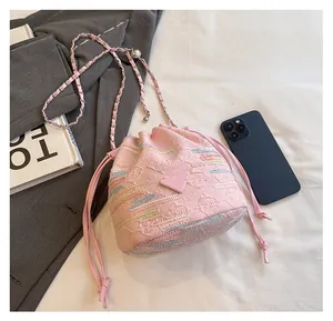 Borsa a secchiello rosa in tessuto jacquard mostrata con smartphone per dimensioni