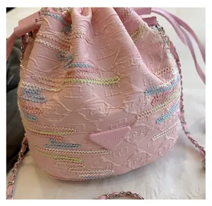 Dettaglio della borsa a secchiello rosa con ricamo a onde colorate e tracolla a catena