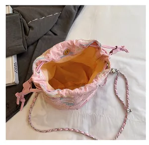 Dettaglio interno della borsa a secchiello rosa intrecciata con chiusura magnetica