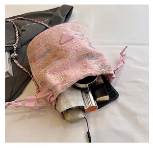 Vista interna del secchiello in jacquard rosa con scomparti per cellulare e rossetto