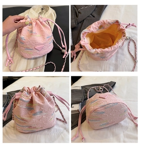 Dettagli di una borsa a secchiello rosa con ricami colorati e catena in argento