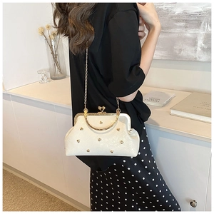 Close-up of white pearlescent doctor bag with gold heart rivets and chain strap