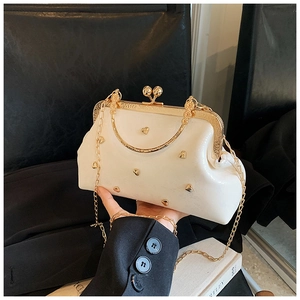 Detail of vintage off-white doctor bag featuring gold heart accents and kiss-lock closure