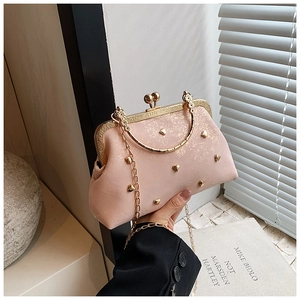 Pink vintage evening clutch bag featuring gold heart rivets and round metal handle