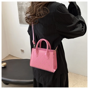 Pink heart-quilted leather handbag with metal studs shown on a model for daily styling