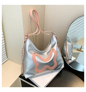 Detailed close-up of metallic silver tote bag with pink butterfly and Y2K metal chains