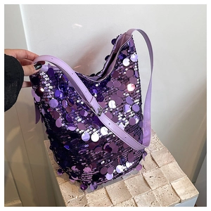 Dettaglio della borsa a secchiello con paillettes viola e tracolla regolabile in pelle