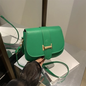 Modern emerald green faux leather crossbody bag with minimalist golden T-buckle closure