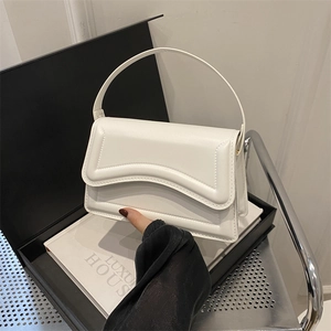 Minimalist white leather handbag with scalloped flap and wave stitching detail