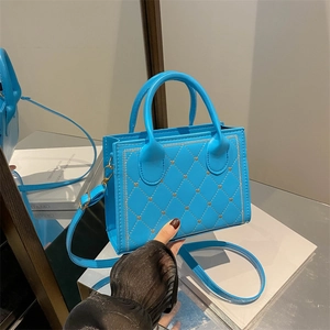 Quilted blue crossbody bag with vintage grid pattern and gold metallic accents