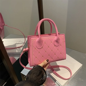 Pink quilted crossbody bag with golden heart studs and circular handles for women