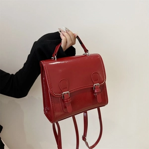 Klassischer roter Lackleder-Rucksack mit Doppel-Schnallenriemen im Retro-College-Stil