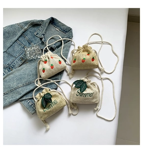 Detail of mini straw bucket bags with strawberry and Summer embroidery and drawstrings