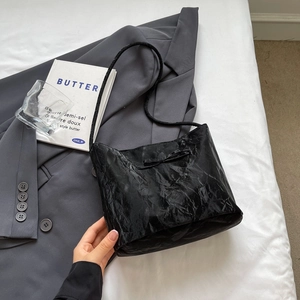 Détail du sac noir plissé avec décoration nœud papillon et fine bandoulière élégante