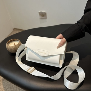 White leather messenger crossbody bag with geometric flap and adjustable strap