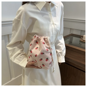 Detail of pink corduroy drawstring bucket bag with cute strawberry pattern