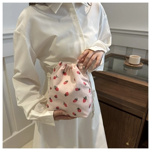 Close-up of pink corduroy drawstring bucket bag with cute strawberry patterns