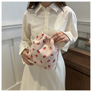 Close-up of pink corduroy drawstring bucket bag with cute red strawberry patterns