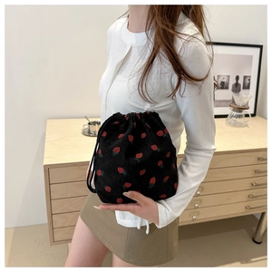 Detail of black corduroy strawberry print bucket bag with drawstring closure