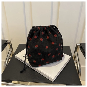 Detail of strawberry print on black corduroy drawstring bucket bag with dual drawstrings