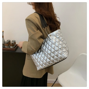 Detail of silver metallic quilted tote bag with diamond stitching and chain shoulder strap