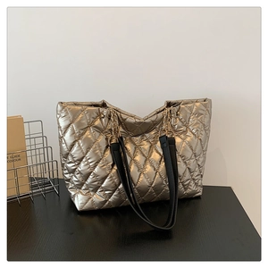Close-up of champagne gold quilted tote bag with diamond stitching and chain strap