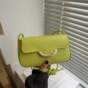 Chic green crossbody bag with gold crescent buckle and long shoulder strap in summer style