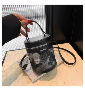 Macro shot of black bucket bag featuring silver butterfly print on a magazine base