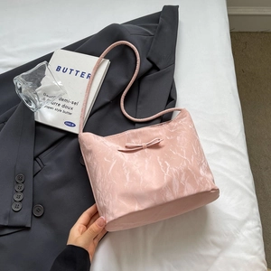 Sac à bandoulière à motif marbre rose avec nœud papillon dans un décor élégant