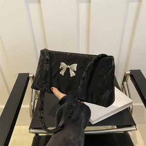 Chic black pleated shoulder bag featuring a silver metal butterfly buckle and slim straps