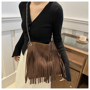 Detail of dark brown suede shoulder bag with long fringes and silver chain strap