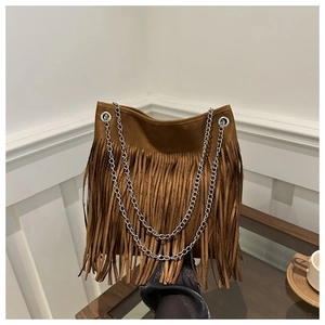 Détail du sac à bandoulière en suédine marron avec de longues franges et des chaînes argentées