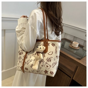 Detail showing high-quality PU tote bag with graffiti prints and cute bear charm pendant