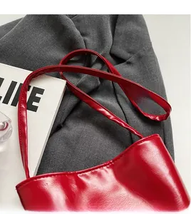 Close-up of red oil-wax leather texture on large capacity bucket bag with thin straps