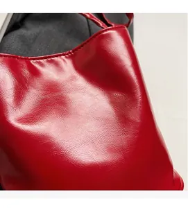 Close-up of red beaded bow bag showing smooth faux leather texture and silver printed logo