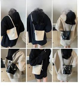 Chic bucket bag with pearl bow charm shown in black and white styles on a model