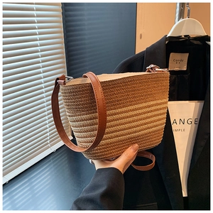 Close-up of the textured woven straw fabric and premium brown leather strap detailing