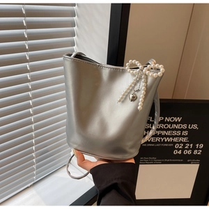 Detailansicht silberne Beuteltasche mit großer Perlschleife und Herzanhänger aus Metall
