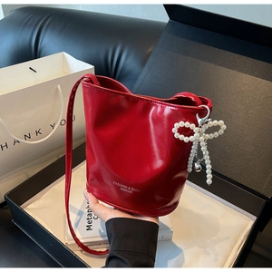 Detail der roten Beuteltasche mit Perlen-Schleife in einer eleganten Geschenkbox