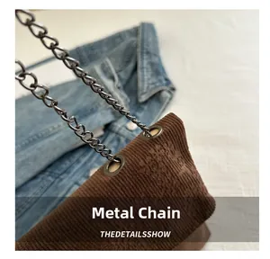 Detail showing the metal chain strap connection and brown corduroy fabric texture
