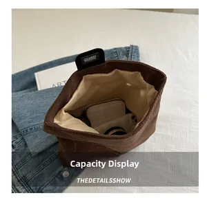 Detail view showing large interior capacity of brown corduroy tote bag with items