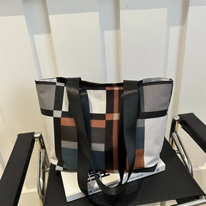 Large geometric tote bag with modern color block pattern and black nylon straps