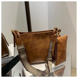 Brown vintage tote bag detail showing textured leather and geometric woven strap