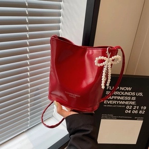 Rote Eimertasche aus Leder mit Perlen-Schleife und modischem weißem Text für Damen