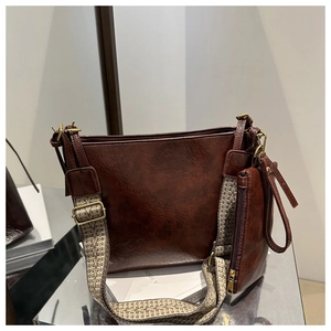 Close-up of chocolate brown tote with herringbone wide strap and gold hardware