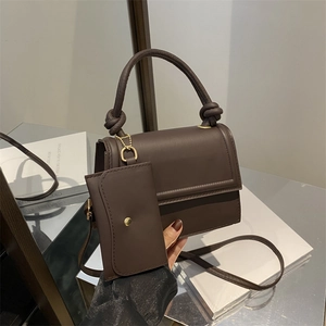 Modern chocolate brown leather crossbody bag with knot handle and small square pendant