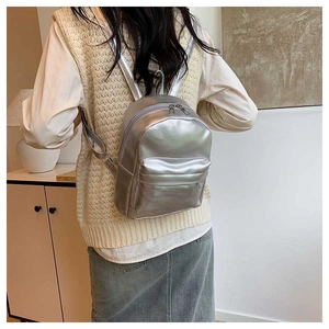 Mini sac à dos argenté métallisé avec double fermeture éclair vu de dos par le modèle